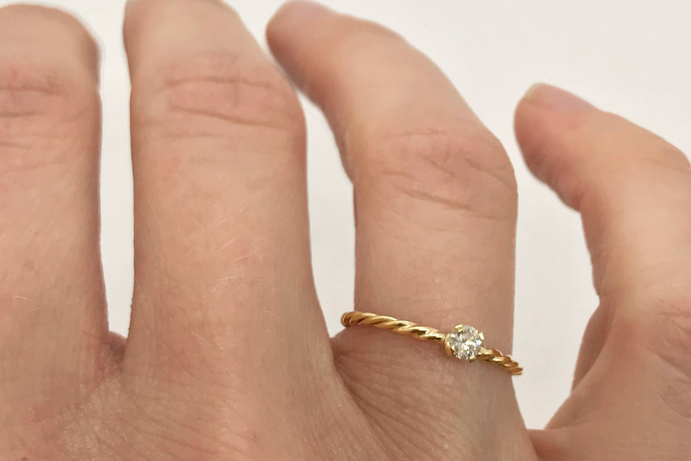 Verlovingsring met gedraaide ringband en diamant