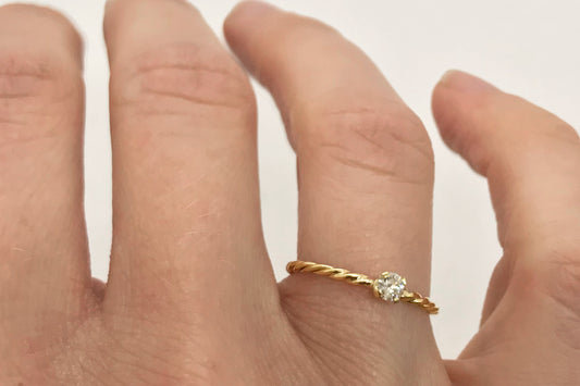 Verlovingsring met gedraaide ringband en diamant